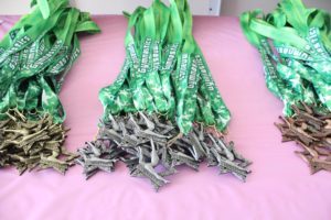 A table with many green ribbons and medals