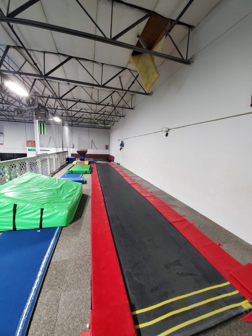 A gym with several different mats and a ramp.