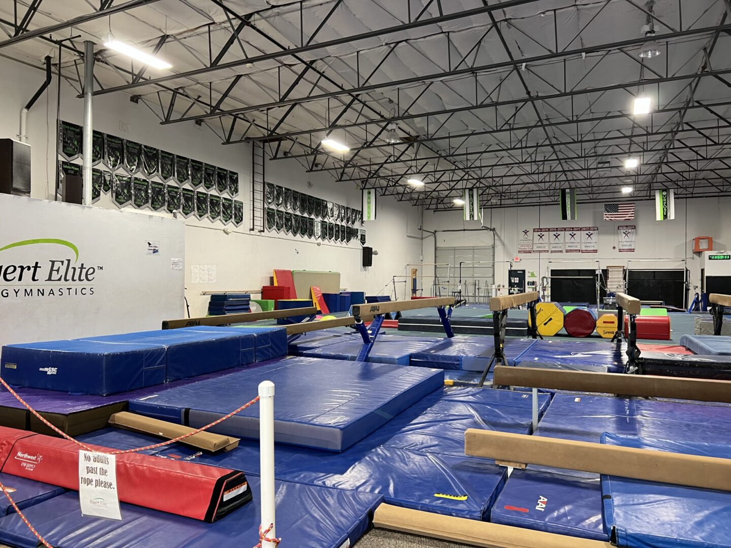 A gym with many different mats and poles.
