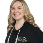 Smiling woman wearing a black Agert Elite Gymnastics hoodie.
