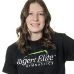Woman smiling in a Rigert Elite Gymnastics shirt.
