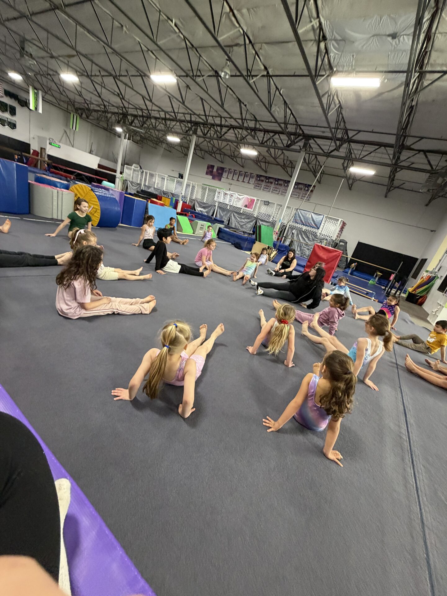 Children stretching in gymnastics class on mat