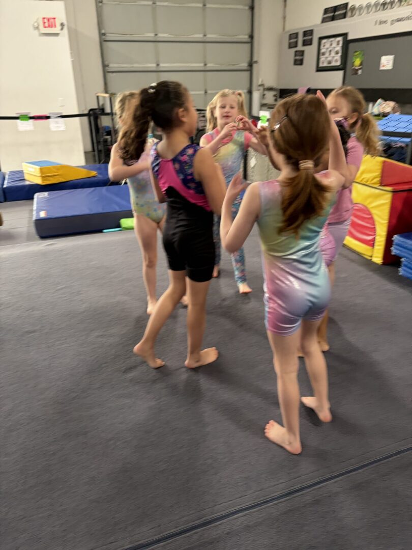 Young gymnasts gathered in gymnasium circle