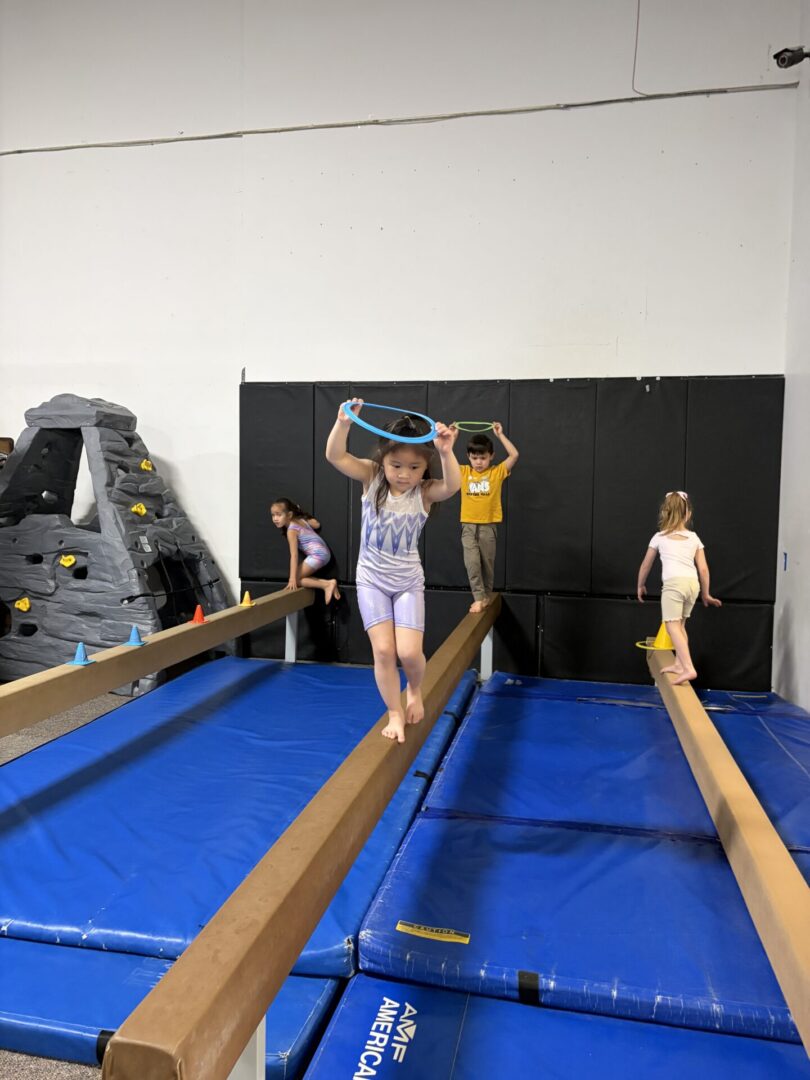 Kids balancing on beams in gymnastics class